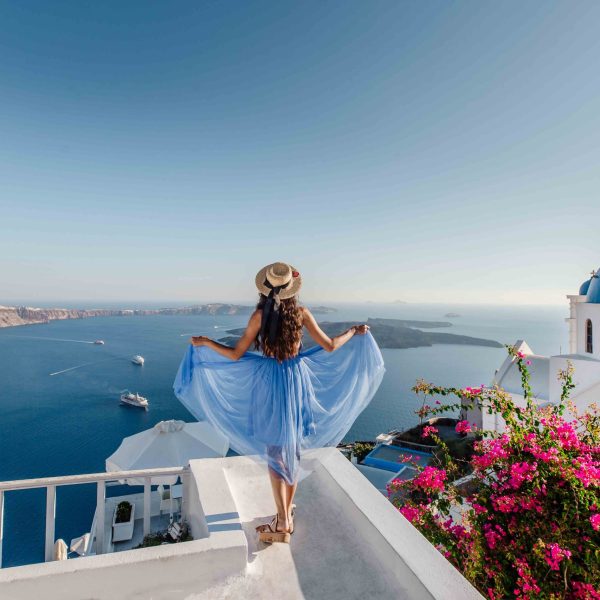 Top destination in Europe, Santorini, Greece. Beautiful woman enojing view on Santorini Island, Cyclades, Greece